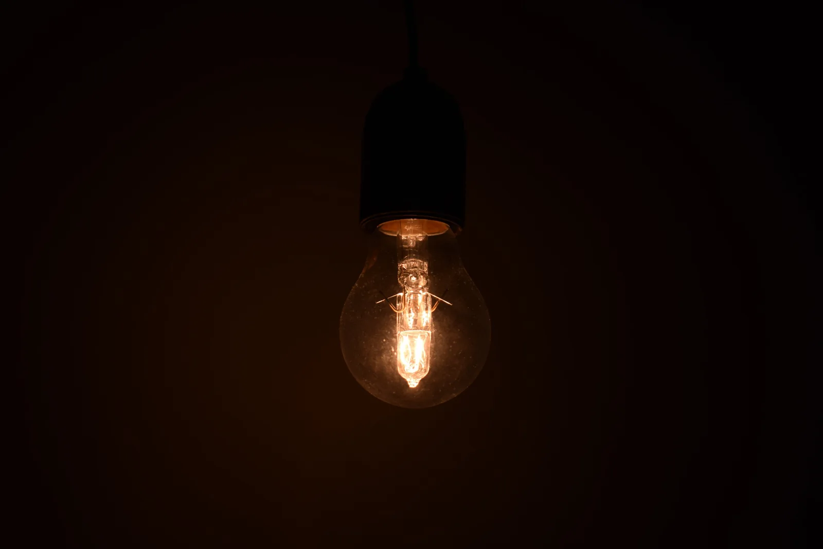 Glowing light bulb in a dark room